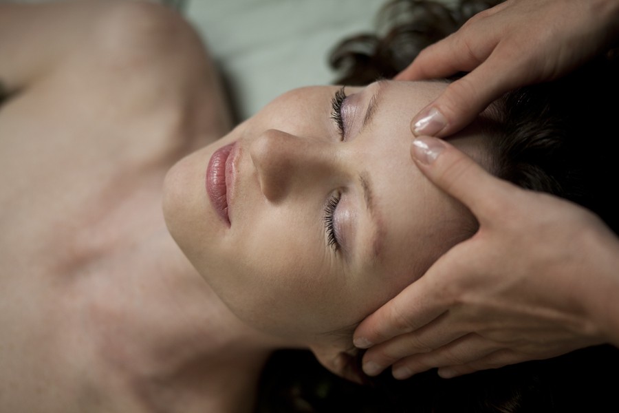 A woman getting her face and neck massaged