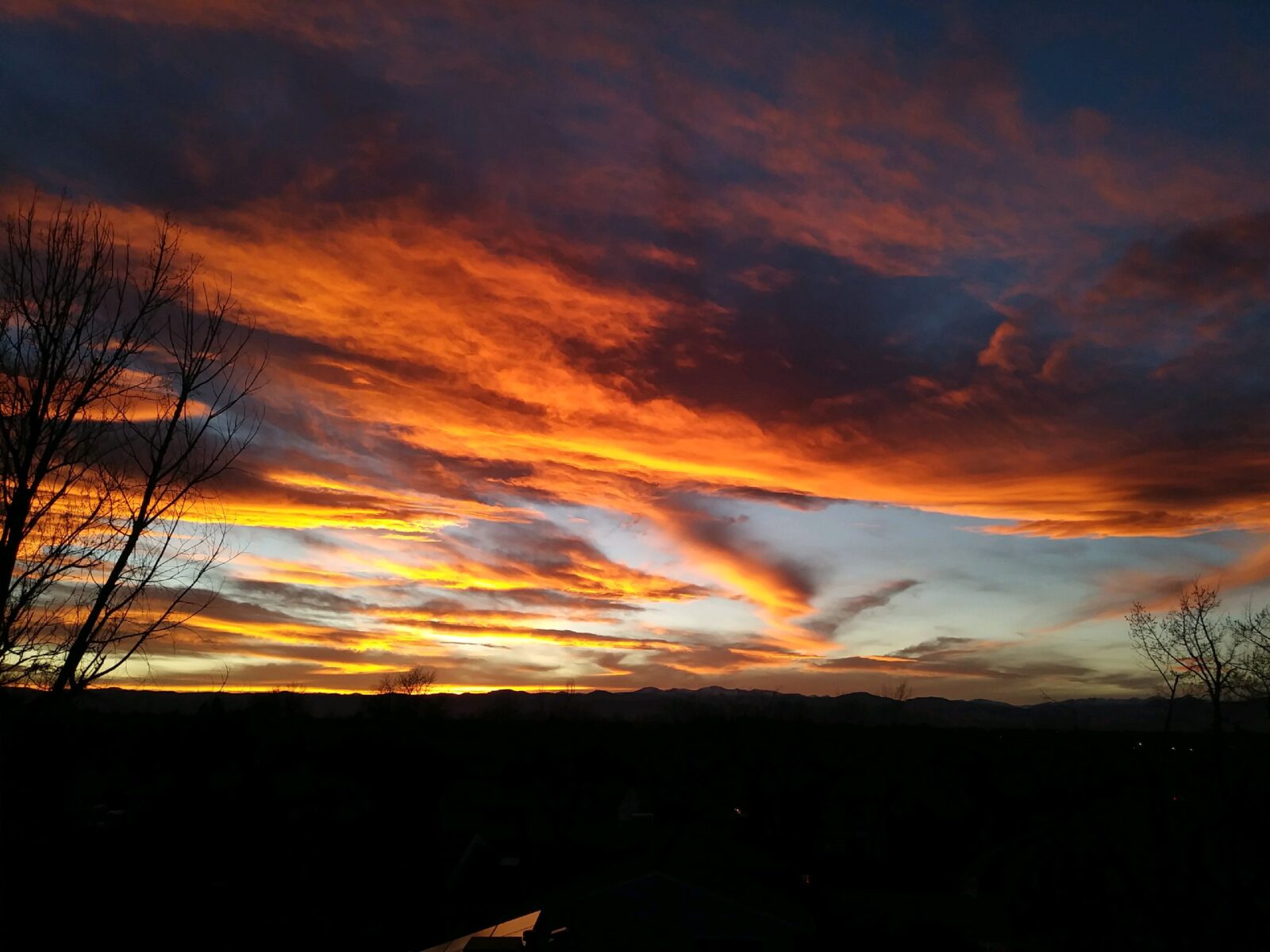 A sunset with orange and red clouds in the sky.