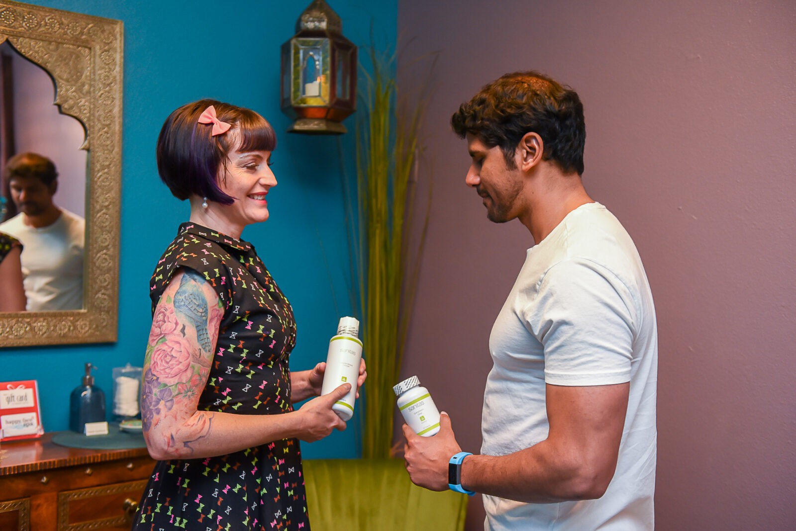 A man and woman holding bottles of lotion.